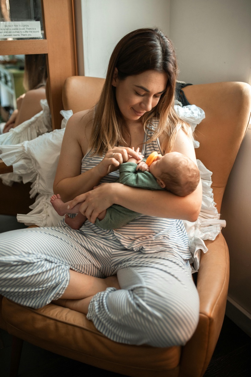 Madre sentada en un sillón sosteniendo a su bebé