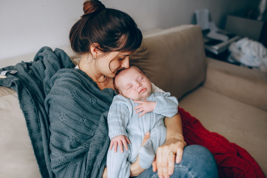 Madre abrazando a su bebé dormido